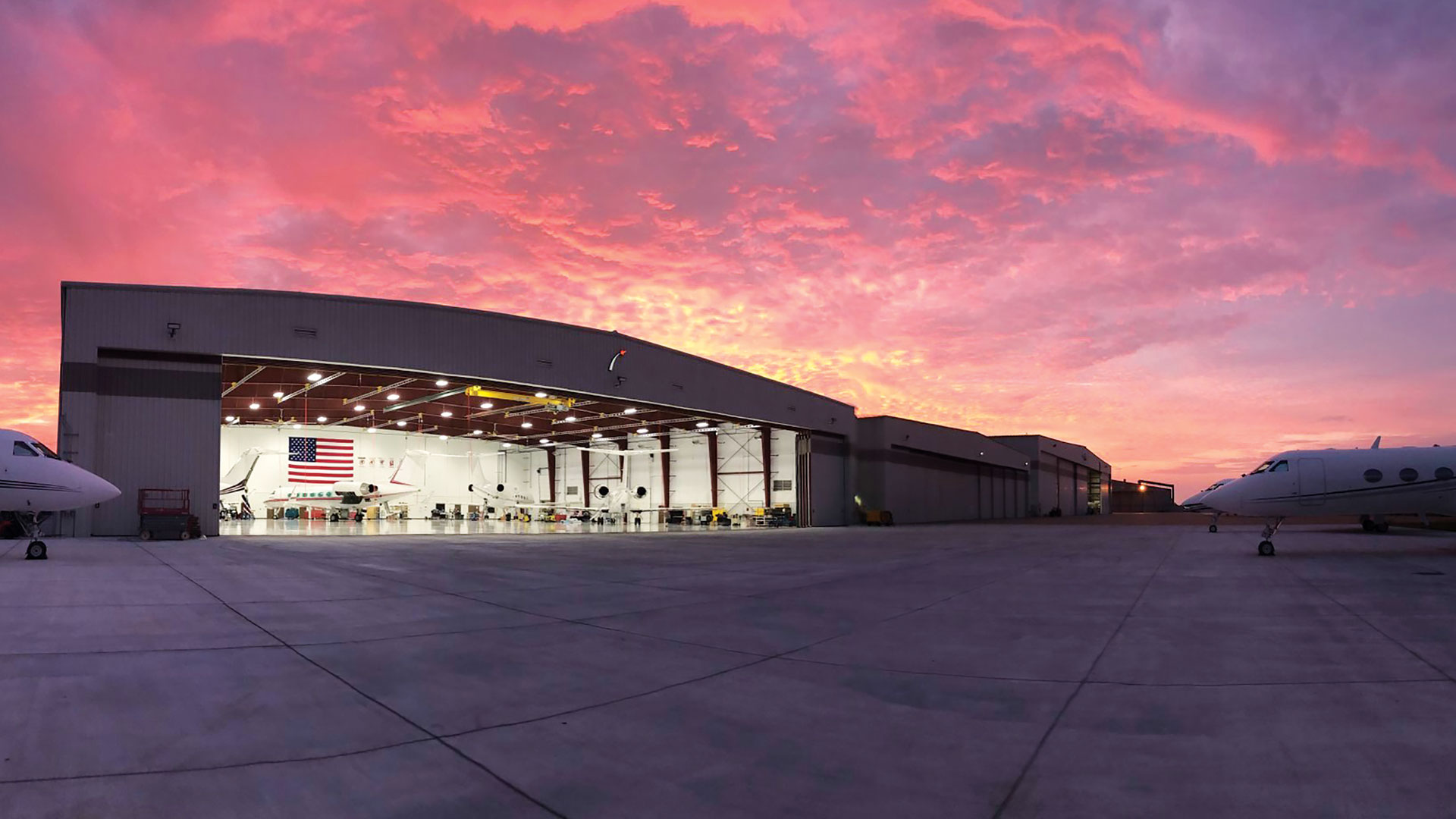 The St. Louis Regional Airport hanger from the outside with jets parked in the foreground.