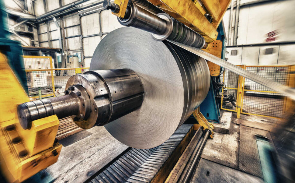 Metal coils machine inside manufacturing facility.